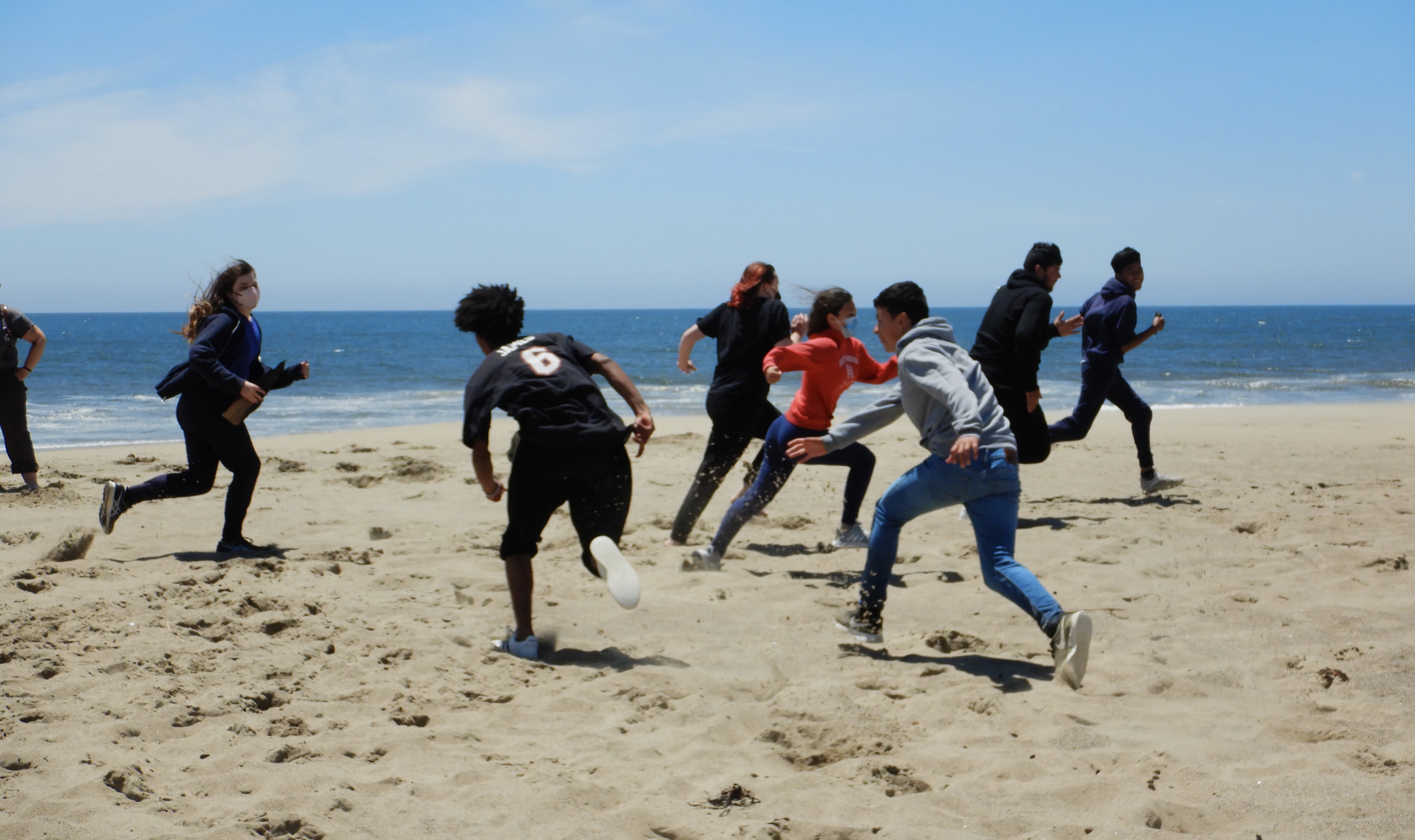 Action photo of Tomales 9th graders playing a game on the beach